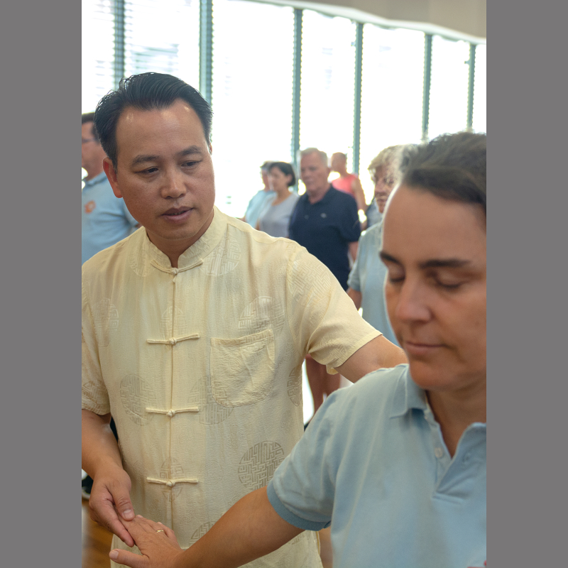 Buyin Zheng helps a student with an exercise